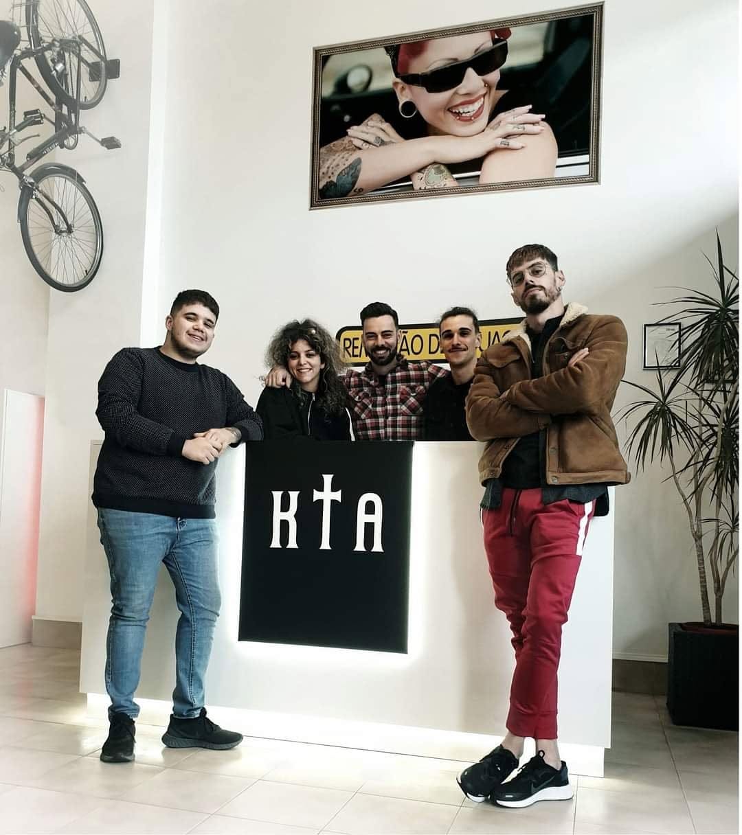 Cinco elementos da equipa junto ao balcão com o logótipo KTA